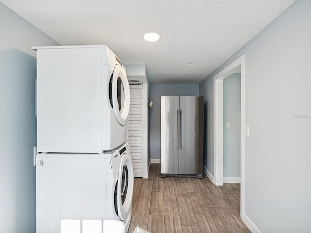 washroom featuring hardwood / wood-style floors and stacked washer and clothes dryer