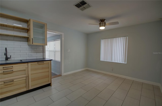 kitchen with light brown cabinetry, backsplash, ceiling fan, sink, and light tile patterned floors