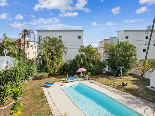 view of swimming pool featuring a patio area and a yard