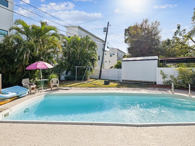 view of swimming pool with a storage shed