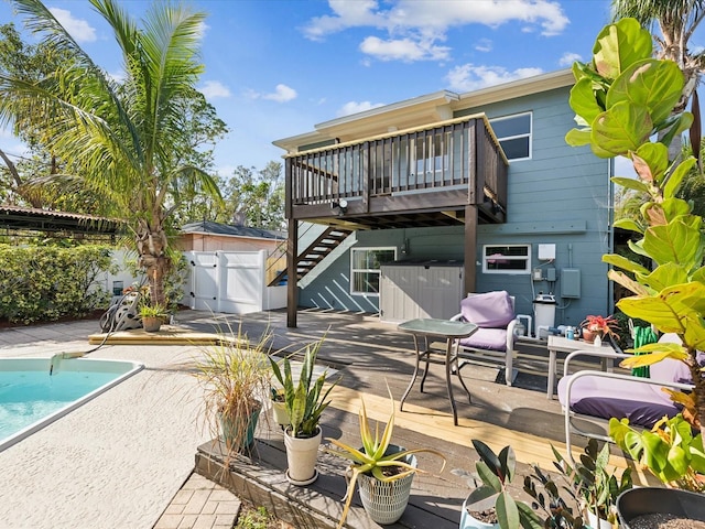 rear view of house featuring a pool side deck and a patio