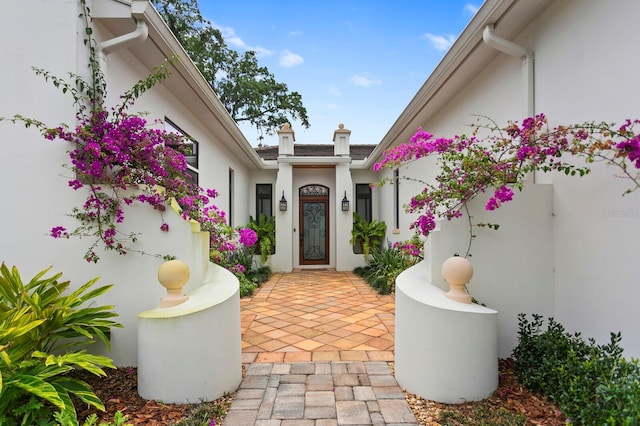 view of exterior entry with a patio area