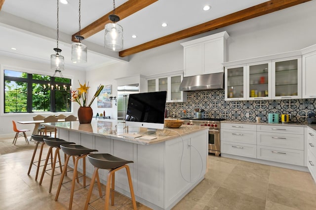 kitchen with an island with sink, high end stainless steel range oven, pendant lighting, light stone counters, and extractor fan