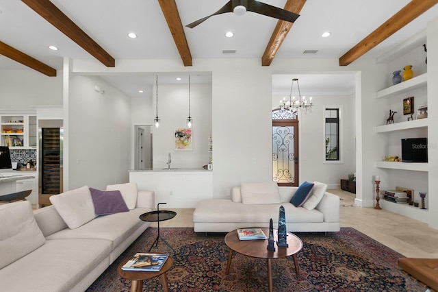 living room with sink, beamed ceiling, built in features, ceiling fan with notable chandelier, and wine cooler