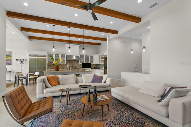 living room featuring tile patterned flooring, beam ceiling, ceiling fan, and sink