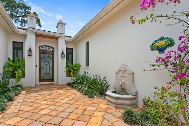 view of exterior entry featuring a patio