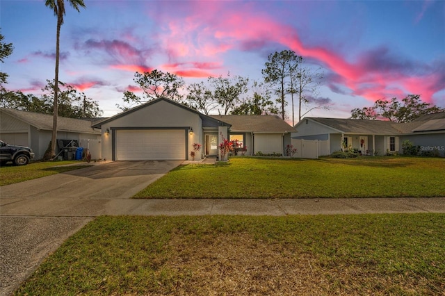 single story home featuring a garage and a lawn