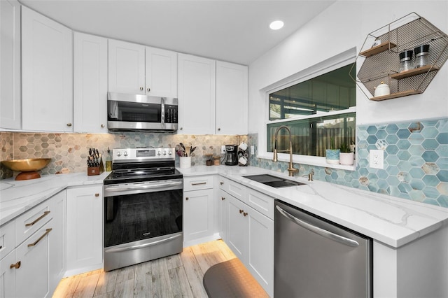 kitchen with sink, white cabinets, and stainless steel appliances