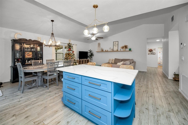 kitchen featuring a wealth of natural light, a kitchen island, light hardwood / wood-style floors, and ceiling fan with notable chandelier