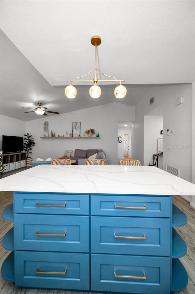 kitchen featuring decorative light fixtures, a center island, dark hardwood / wood-style floors, and ceiling fan