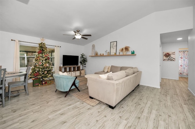 living room featuring ceiling fan, light hardwood / wood-style floors, and vaulted ceiling