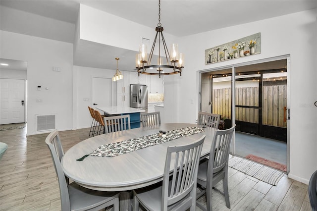 dining area featuring a notable chandelier and light hardwood / wood-style floors