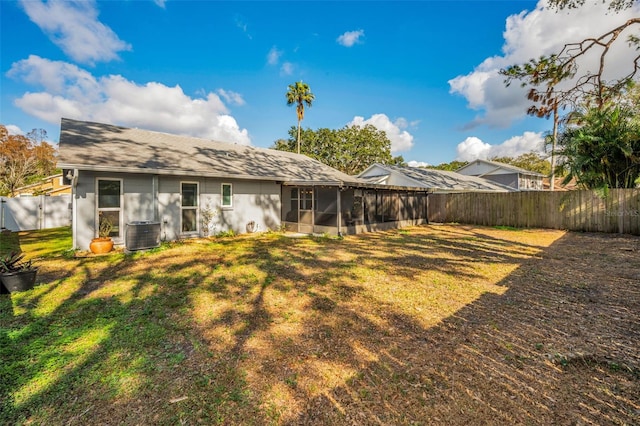 back of property featuring central AC unit and a yard