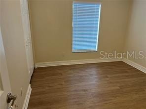 spare room with dark hardwood / wood-style flooring