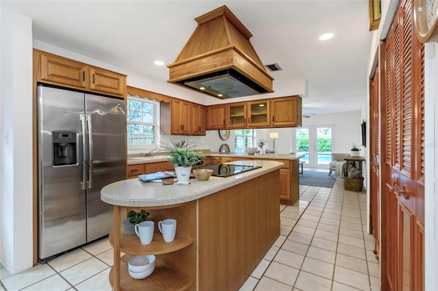 kitchen featuring a center island, a healthy amount of sunlight, stainless steel refrigerator with ice dispenser, and custom exhaust hood