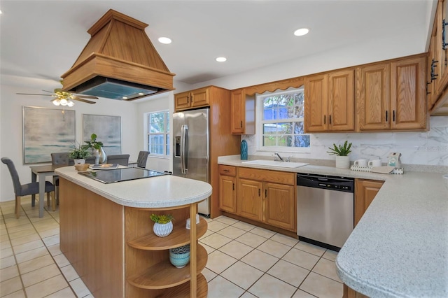 kitchen with a wealth of natural light, premium range hood, sink, and appliances with stainless steel finishes