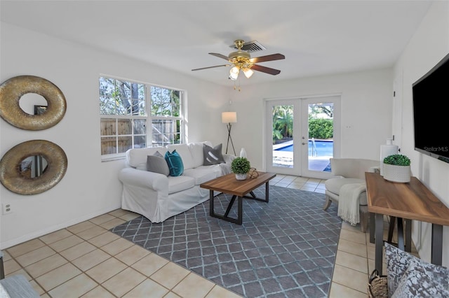 tiled living room with ceiling fan and french doors