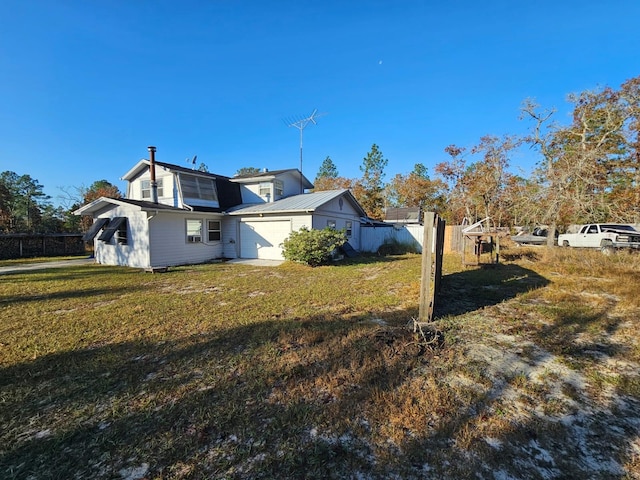 view of home's exterior featuring a lawn and a garage