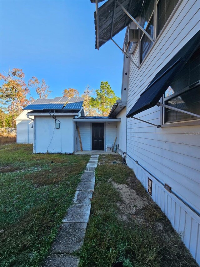 view of home's exterior with a lawn and solar panels