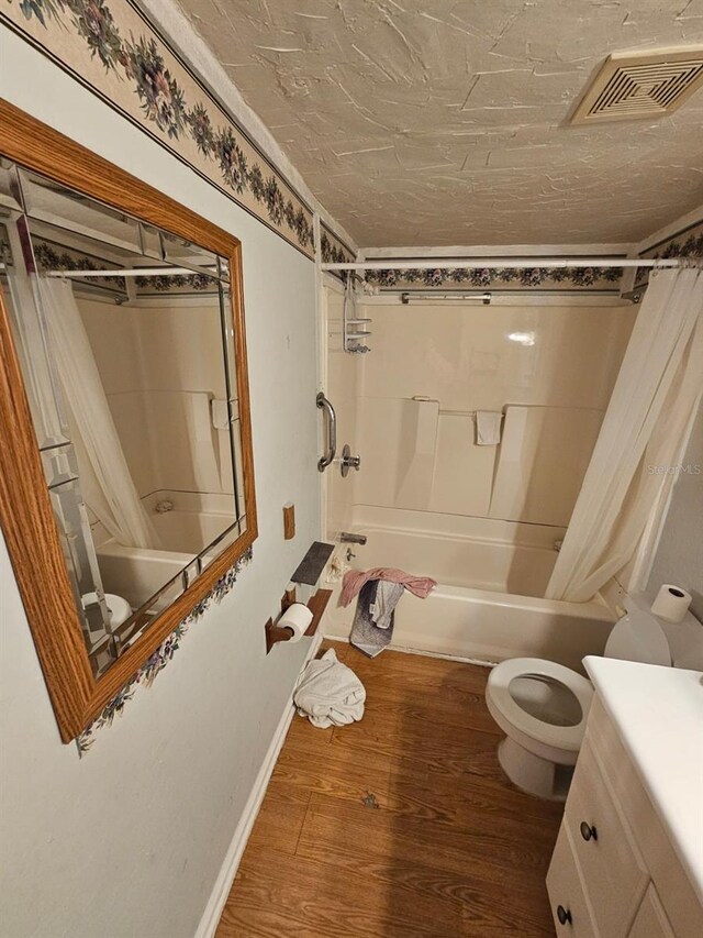 full bathroom featuring toilet, shower / tub combo with curtain, vanity, and hardwood / wood-style flooring