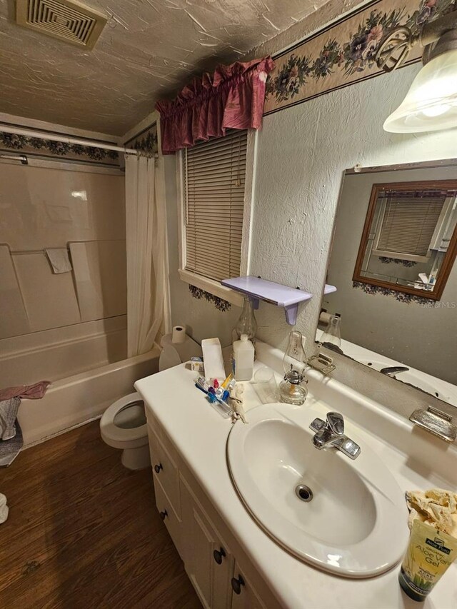 full bathroom with toilet, hardwood / wood-style floors, vanity, and shower / tub combo with curtain