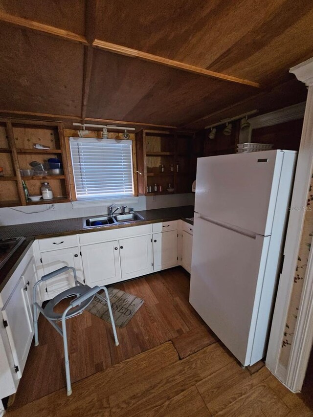 kitchen with sink, dark hardwood / wood-style floors, white refrigerator, white cabinets, and wood ceiling