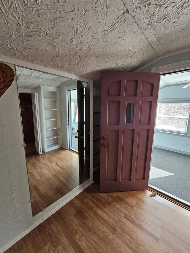 entrance foyer with vaulted ceiling and hardwood / wood-style flooring