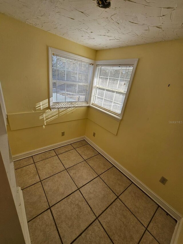 unfurnished room featuring a wealth of natural light and light tile patterned flooring