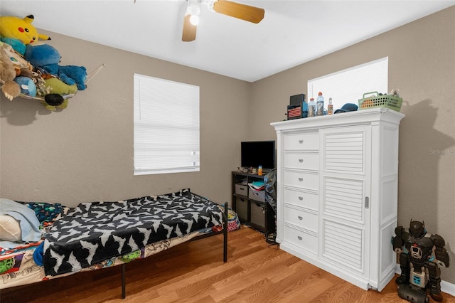 bedroom with multiple windows, light hardwood / wood-style flooring, and ceiling fan