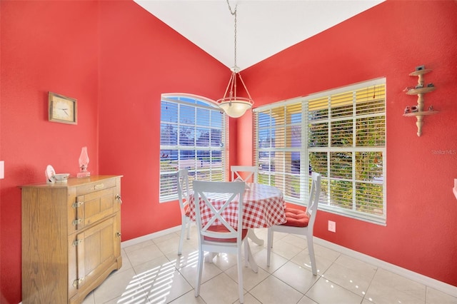 tiled dining room featuring lofted ceiling and a healthy amount of sunlight