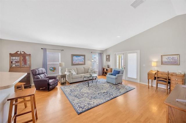 living room featuring french doors, vaulted ceiling, and light wood-type flooring