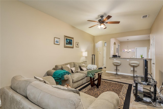 living room featuring ceiling fan with notable chandelier