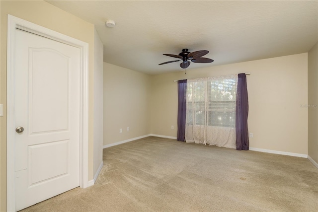 empty room with ceiling fan and light colored carpet