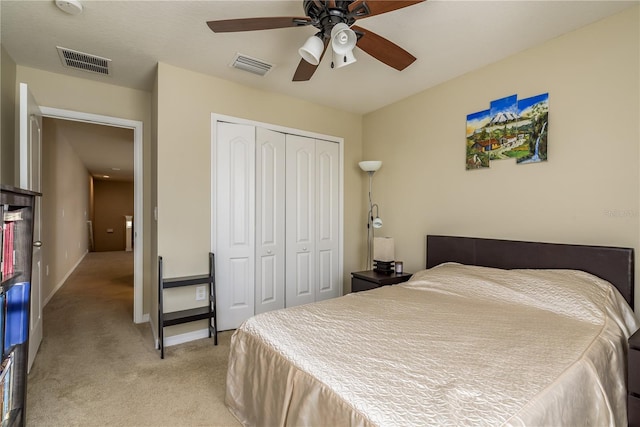 bedroom with ceiling fan, a closet, and light carpet