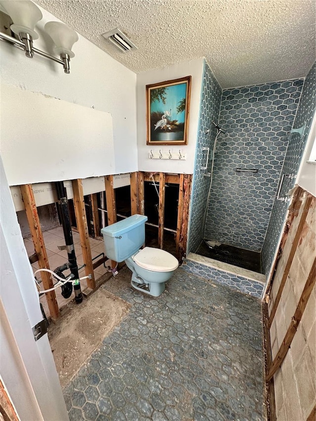 bathroom with toilet, a textured ceiling, and walk in shower