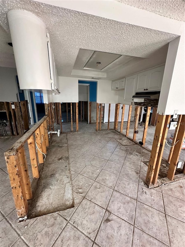 interior space with light tile patterned floors and a textured ceiling