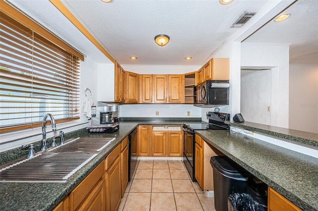 kitchen featuring light tile patterned flooring, a textured ceiling, sink, and black appliances