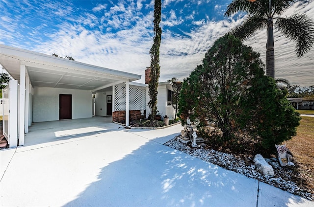 view of snowy exterior with a carport