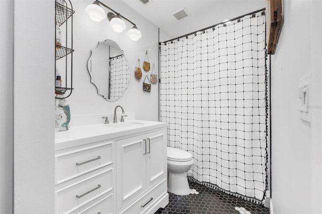 bathroom featuring tile patterned flooring, a shower with curtain, vanity, and toilet