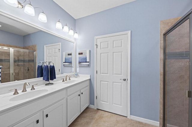 bathroom with tile patterned flooring, vanity, and walk in shower