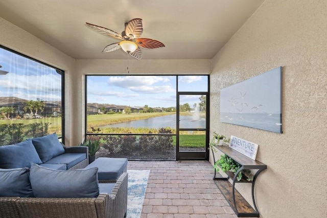 sunroom / solarium featuring a water view and ceiling fan