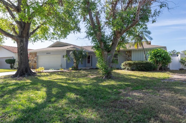 ranch-style home featuring a front lawn and a garage