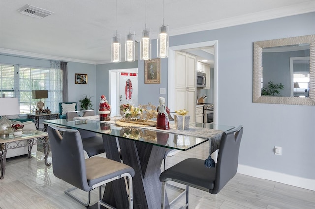 dining room with crown molding and light hardwood / wood-style flooring