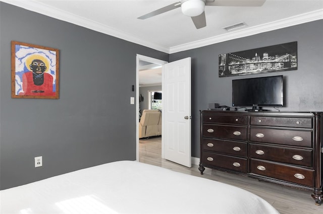 bedroom featuring ceiling fan, ornamental molding, and light wood-type flooring