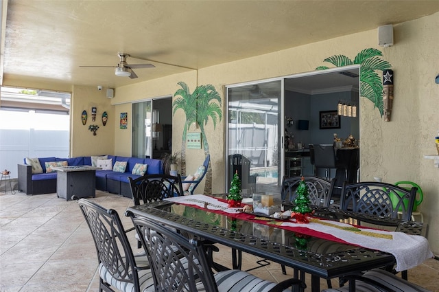 view of patio with outdoor dining space, fence, ceiling fan, and an outdoor hangout area