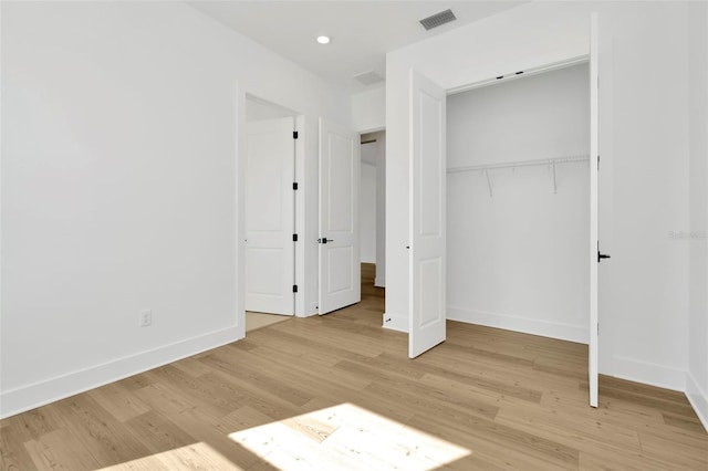 unfurnished bedroom featuring a closet and light hardwood / wood-style flooring