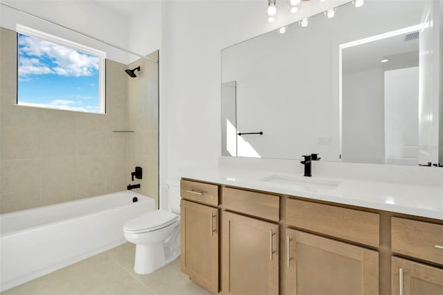 full bathroom with tile patterned floors, vanity, tiled shower / bath, and toilet