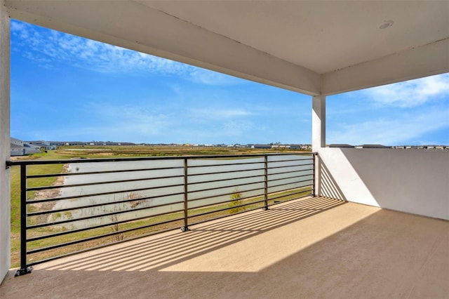 view of patio / terrace with a balcony and a water view