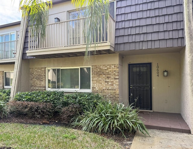 view of exterior entry with a balcony