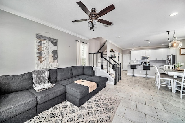 tiled living room with ceiling fan and crown molding